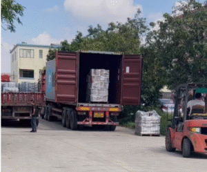 LED flood light SKD kits loading for export to Morocco, packed pallets being loaded into container at Sunlux LED Lighting factory