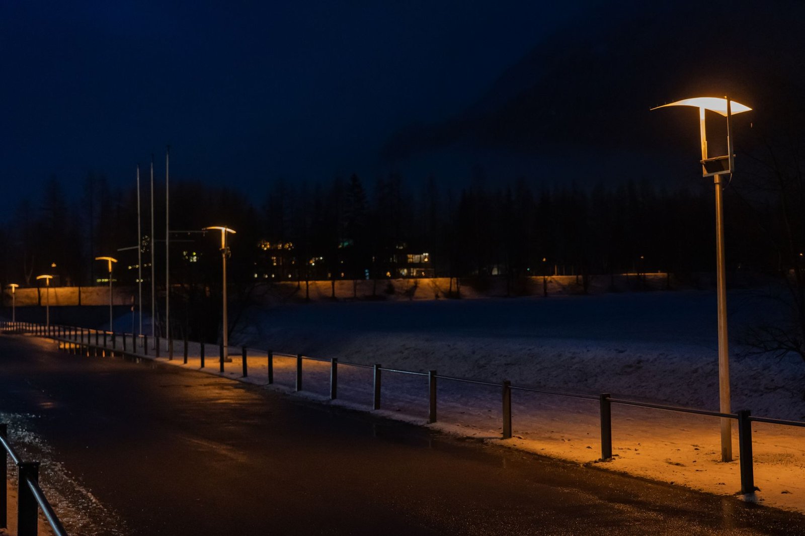 Street lamp illuminating a road at night with light output comparison