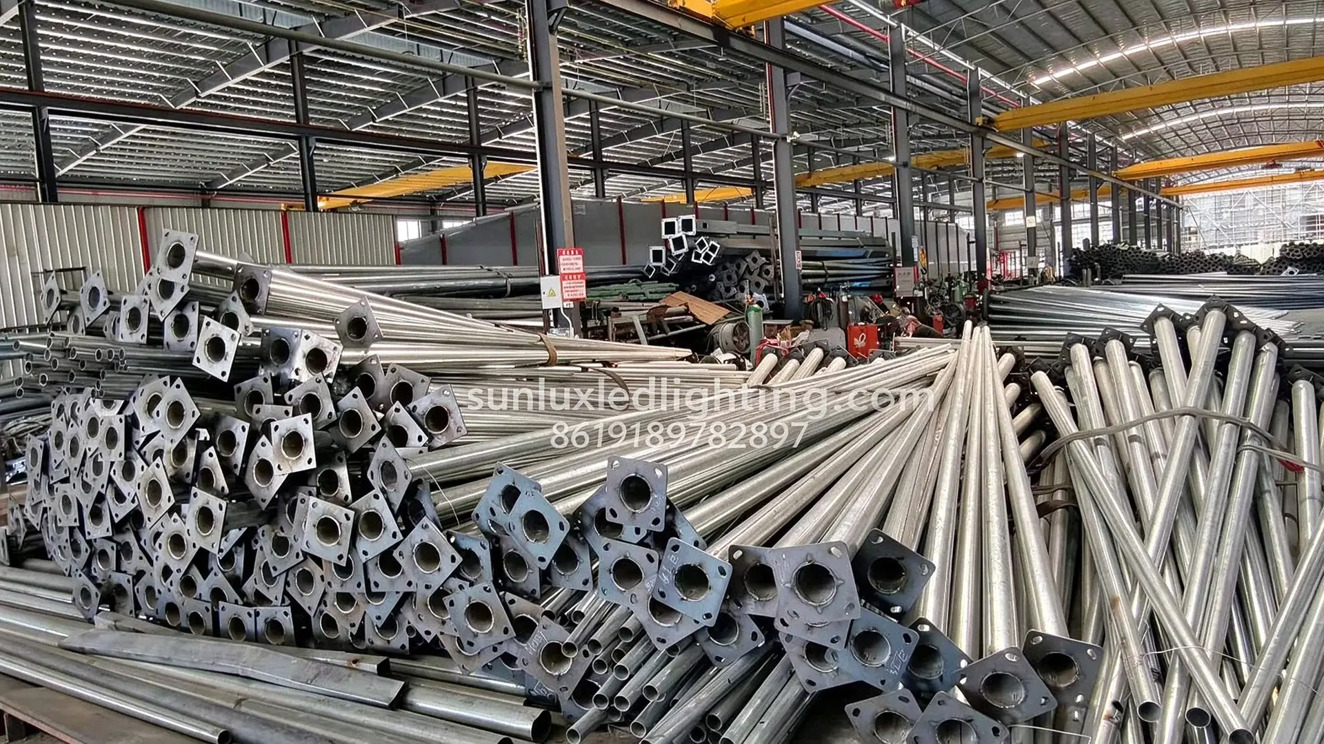 Steel lighting pole sections stacked at SUNLUX factory before handling and shipment