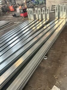 Fabricated steel lighting pole sections in production workshop