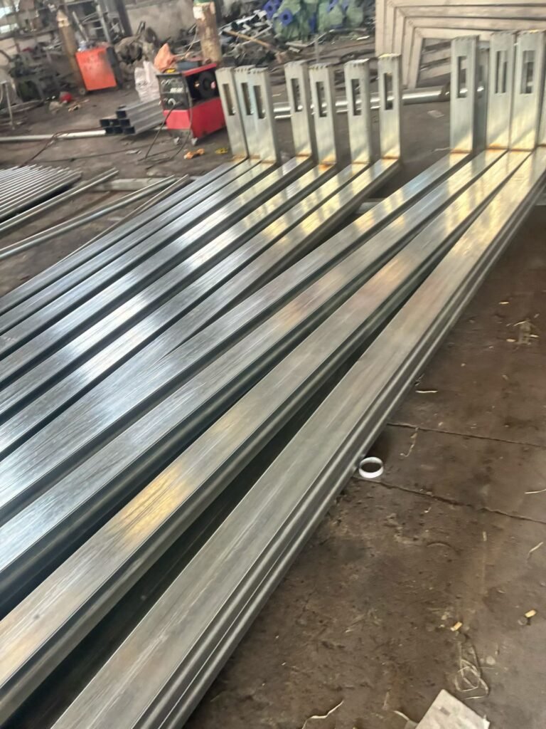 Fabricated steel lighting pole sections in production workshop