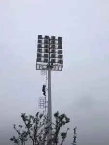 High mast lighting pole with maintenance ladder platform and floodlight array